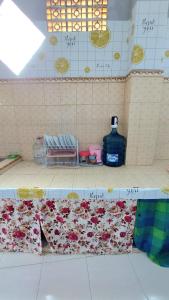 a counter in a bathroom with flowers on it at Penginapan Syariah Dhifa Indonesian only in Bukittinggi