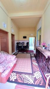 a living room with a bed and a dining room at Penginapan Syariah Dhifa Indonesian only in Bukittinggi