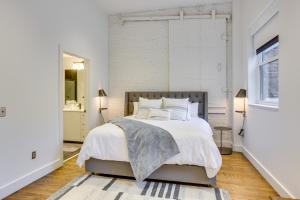 a white bedroom with a large bed and a window at Downtown Omaha Getaway with Deck and Gas Grill! in Omaha