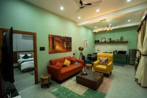 sala de estar con sofá y silla en Barefoot Homestays en Rāmnagar