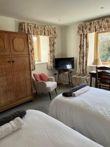 uma sala de estar com duas camas e uma televisão em The Norfolk Haybarn em Sedgeford