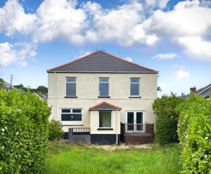 una casa blanca con techo negro en Large house on the edge of the Brecon Beacons en Beaufort