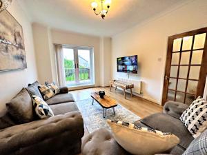 uma sala de estar com um sofá e uma mesa em Large house on the edge of the Brecon Beacons em Beaufort