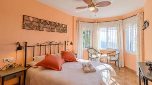sypialnia z łóżkiem z pomarańczowymi ścianami w obiekcie Casa Los Almendrales Torrox by Ruralidays w mieście Torrox +36 zdjęć