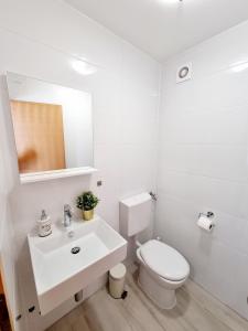 a white bathroom with a toilet and a sink at Sea view App Mirta in Umag +16 photos