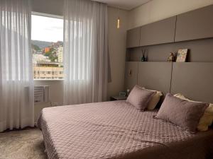 a bedroom with a large bed with a window at Apartamento Luxo Copacabana com vista Cristo Redentor in Rio de Janeiro