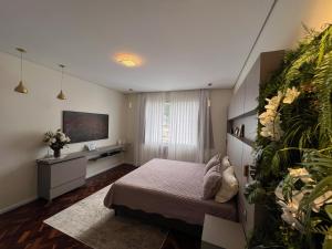 a bedroom with a bed and a desk and a television at Apartamento Luxo Copacabana com vista Cristo Redentor in Rio de Janeiro