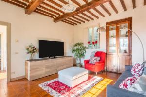 sala de estar con TV y silla roja en * Farmhouse with views * Walk to everything en Barga