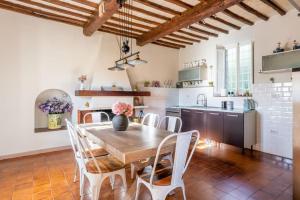 cocina con mesa de madera y sillas blancas en * Farmhouse with views * Walk to everything en Barga