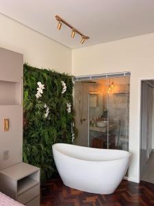 a white bath tub in a bathroom with a green wall at Apartamento Luxo Copacabana com vista Cristo Redentor in Rio de Janeiro +12 photos