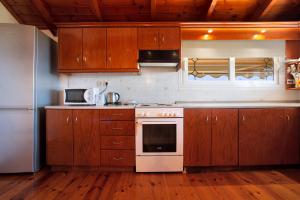 a kitchen with wooden cabinets and a white stove top oven at Zante View Apartment in Planos