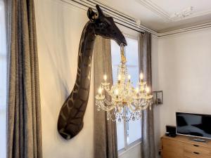 a giraffe head on a wall next to a chandelier at L'Antre des Papes in Avignon