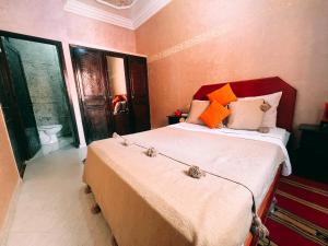 a bedroom with a large bed with orange and white pillows at Original Surf Morocco in Tamraght Ouzdar