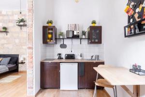 eine Küche mit Holzschränken und einer weißen Wand in der Unterkunft Vintage Style Cozy Downtown Apartment. in Budapest