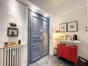 a hallway with a blue door and a red cabinet at L'Antre des Papes in Avignon