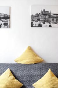 ein schwarz-weißes Foto eines Bettes mit gelben Kissen in der Unterkunft Vintage Style Cozy Downtown Apartment. in Budapest