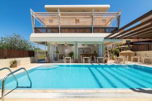 a house with a swimming pool in front of a house at GOJI Vegan Hotel in Ialyssos