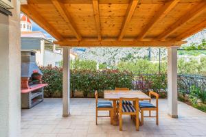 pérgola de madera con mesa y sillas en el patio en Downtown Deluxe, en Omiš