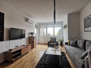 a living room with a couch and a flat screen tv at Downtown apartment in Subotica