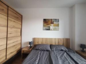 a bedroom with a bed with a wooden headboard at Downtown apartment in Subotica