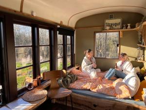 zwei Personen auf einem Bett in einem Zimmer mit Fenstern in der Unterkunft Sol-flora in Tjele