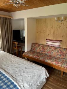 ein Hotelzimmer mit einem Sofa und einem Bett in der Unterkunft "Terrasse" Nessental in Gadmen