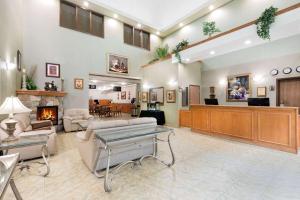 a lobby with a waiting room and a fireplace at Ramada by Wyndham Clairmont/Grande Prairie in Clairmont