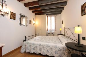 a bedroom with a bed and a table and a window at Residence dei Mori in Venice