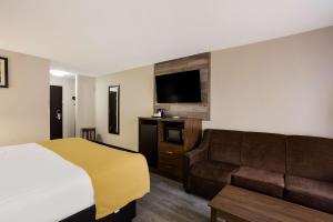 a hotel room with a bed and a couch at Best Western Crossroads Inn in Schererville