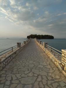 ein Gehweg, der auf einem Pier ins Wasser führt in der Unterkunft B&B one in Vónitsa