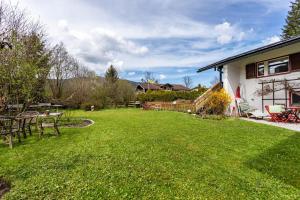 a yard with a table and chairs and a house at Haus Alpenveilchen - Appartement 1 in Schönau am Königssee