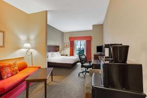 a hotel room with a bed and a living room at La Quinta by Wyndham Richmond - Kings Dominion in Doswell