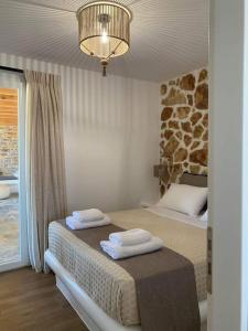 una camera con due letti e un lampadario a braccio di Marikos House, Pyrgaki Alyko Naxos a Spiaggia di Aliko