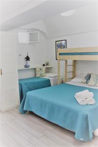 a bedroom with a blue bed with towels on it at La Maiolica in Anacapri