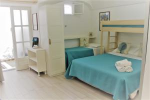 een slaapkamer met een bed en een stapelbed bij La Maiolica in Anacapri