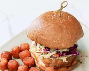 ein Sandwich auf einem Teller mit einer Seite von Kartoffeltots in der Unterkunft Hyatt Regency Houston West in Houston