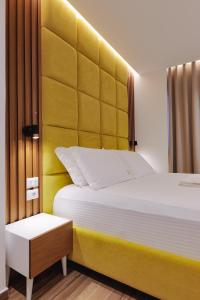 a bedroom with a large bed with a yellow headboard at HOTEL RENATO in Ksamil