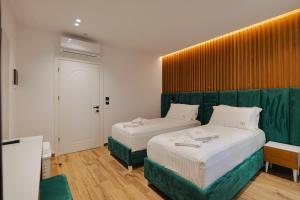 sypialnia z 2 łóżkami i zielonym zagłówkiem w obiekcie HOTEL RENATO w mieście Ksamil