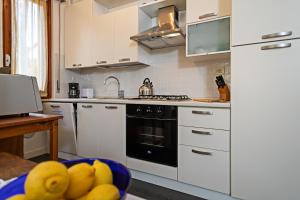 een keuken met witte apparatuur en een fruitschaal bij EDDA - Regarda Travel in Lazise