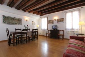 Residence dei Mori في البندقية: غرفة معيشة مع طاولة وكراسي وأريكة
