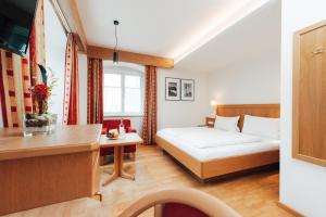 a hotel room with a bed and a desk at Hotel Drei König in Immenstadt im Allgäu