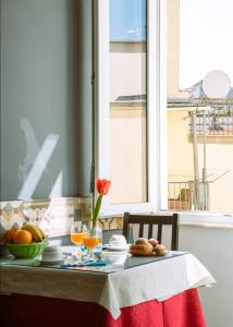 - une table avec un bol de fruits et une fenêtre dans l'établissement Carafa Suite By Enjoy Napoli, à Naples