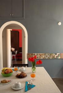 une table avec un vase de fleurs rouges sur elle dans l'établissement Carafa Suite By Enjoy Napoli, à Naples