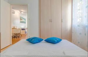 two blue pillows sitting on a bed in a bedroom at Apartment Promenade Zlatni Rat in Bol