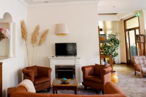 a living room with two chairs and a fireplace at Hotel Delle Ortensie in Fiuggi