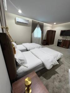 a hotel room with two beds and a television at السلطان للشقق المفروشة in AlUla