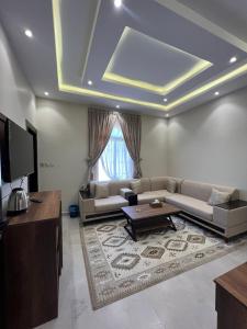 - un salon avec un canapé et une table dans l'établissement السلطان للشقق المفروشة, à Al-Ula