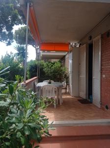 un patio con mesa y sillas. en A casa di Ale en Castiglione della Pescaia