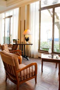 een woonkamer met stoelen en een tafel en ramen bij Hotel Delle Ortensie in Fiuggi