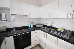 cocina blanca con fregadero y lavavajillas en Seagull 514, en Margate